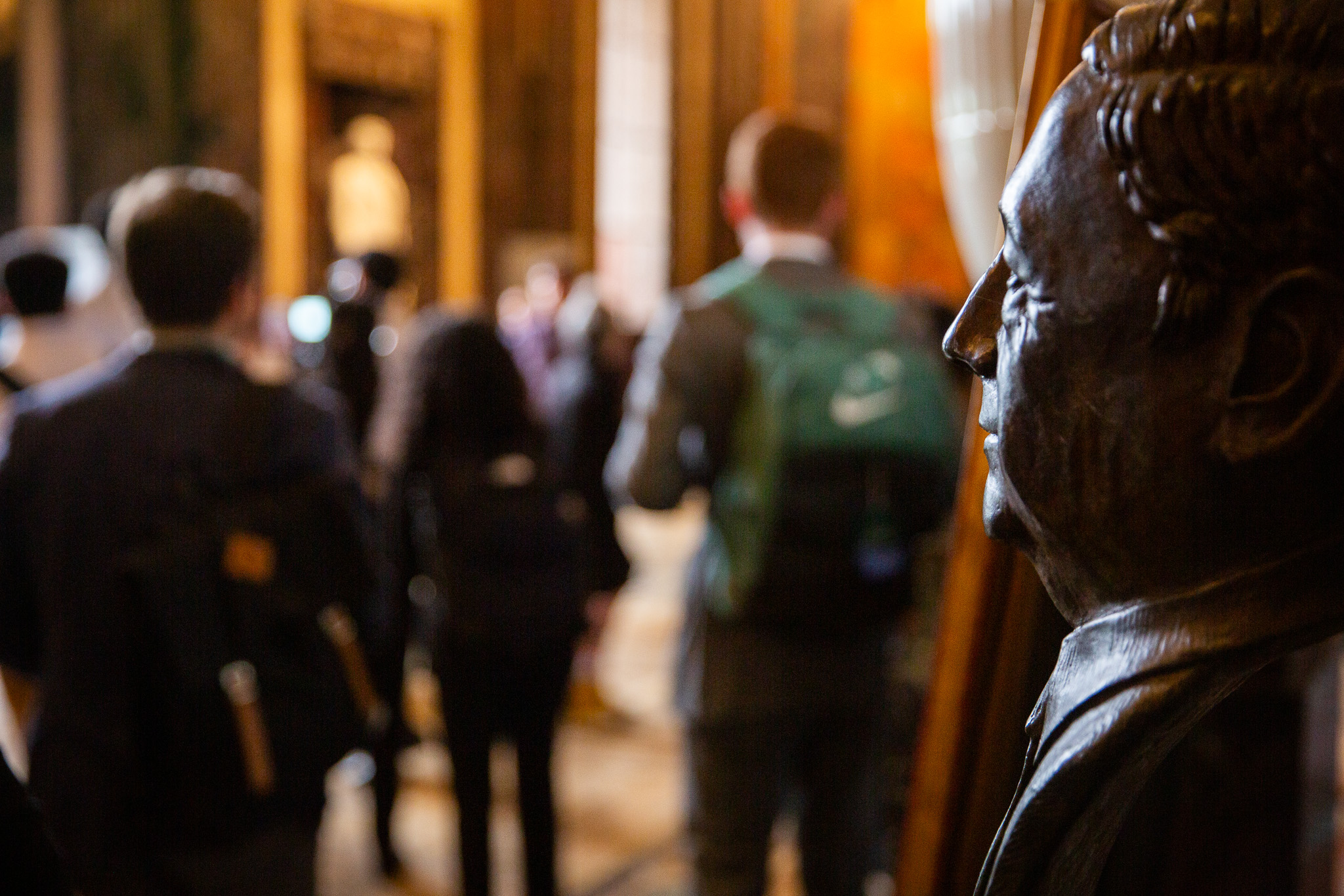 Blurred students and a bust of a political leader at the Louisiana State Capitol