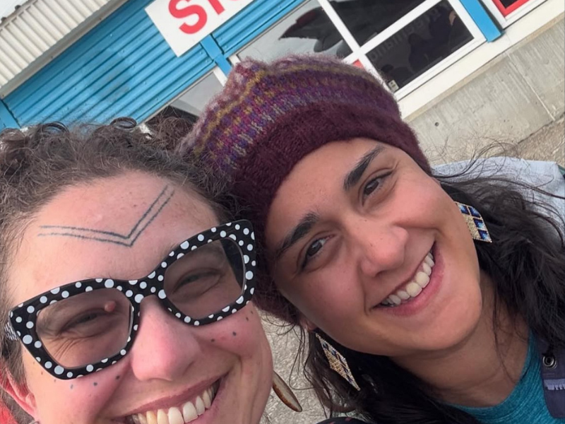 Mariah Seater (left) and Dr. Heather Gordon pose for a selfie; one wears polka dot glasses, the other a knit hat.
