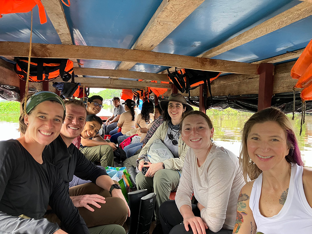 A group of people on a boat smiling, facing camera