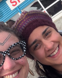 Mariah Seater (left) and Dr. Heather Gordon pose for a selfie; one wears polka dot glasses, the other a knit hat.