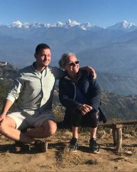 Nancy Mock with her son, Alex, in Nepal, mountains in the background, sun shining on them. 